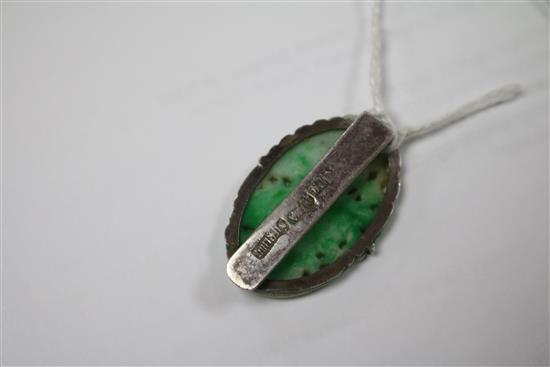 A 19ct century carved jadeite plaque, in later Chinese white metal brooch mount, 36mm.